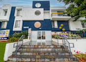 Thumbnail 12 of 14 - a blue and white building with yellow balloons in front of it