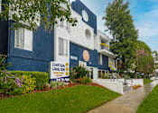 Thumbnail 9 of 14 - a blue and white building with a sign in front of it
