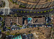 Thumbnail 11 of 11 - A bird's eye view of a residential area with houses and parked cars.