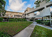 Thumbnail 38 of 46 - A concrete building with a walkway in front of it.