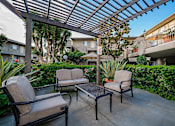 Thumbnail 3 of 46 - A patio with a table and chairs under a roof.