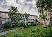 Thumbnail 37 of 46 - Apartment complex with greenery in front.
