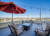Thumbnail 2 of 25 - A patio with two chairs and a table with a view of the city.