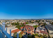 Thumbnail 25 of 25 - A white fence in front of a house with a view of a city and mountains in the background.