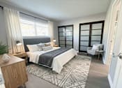 Thumbnail 17 of 35 - A bedroom with a large bed and a chair.