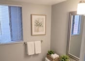 Thumbnail 8 of 20 - A bathroom with a toilet, sink, and mirror.