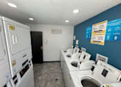 Thumbnail 10 of 19 - a laundry room with a bunch of washes and dryers
