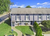 Thumbnail 2 of 35 - the front of a gray house with a yard and a road