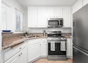 Thumbnail 55 of 67 - A kitchen with white cabinets and a granite countertop.