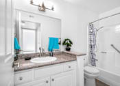 Thumbnail 61 of 67 - A bathroom with a white sink and a white toilet.