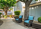 Thumbnail 20 of 67 - Two chairs with blue cushions are placed on a patio.
