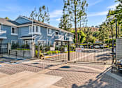 Thumbnail 35 of 67 - A gated entrance to a residential complex with a blue building.
