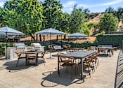 Thumbnail 28 of 67 - A patio with tables and chairs under umbrellas.