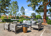 Thumbnail 5 of 67 - A patio with a table and chairs surrounded by trees.