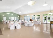 Thumbnail 43 of 67 - A room with tables set up for a function.