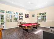 Thumbnail 32 of 67 - A pool table is in the middle of a room with a couch and chairs.