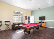 Thumbnail 6 of 67 - A room with a pool table and a television.