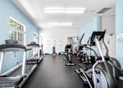 Thumbnail 40 of 67 - A spacious gym with treadmills, elliptical machines, and other exercise equipment.
