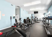 Thumbnail 42 of 67 - A gym with treadmills, exercise bikes, and other equipment.