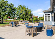 Thumbnail 25 of 67 - A patio with a table and chairs is surrounded by trees.