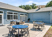 Thumbnail 31 of 67 - A blue house with a patio and a table.
