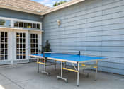 Thumbnail 18 of 67 - A blue ping pong table is set up on a patio.