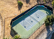 Thumbnail 8 of 67 - An aerial view of a tennis court surrounded by a fence.