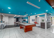 Thumbnail 4 of 49 - A room with a pool table and a kitchen area.