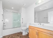 Thumbnail 14 of 49 - A bathroom with a toilet, sink, and walk-in shower.
