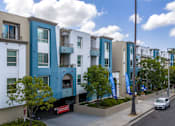 Thumbnail 2 of 49 - A row of modern apartment buildings with balconies and trees in front.