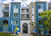Thumbnail 1 of 49 - A modern apartment building with balconies and a blue and white facade.