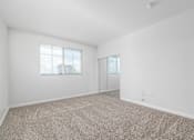 Thumbnail 22 of 49 - A room with a carpeted floor and a window with blinds.