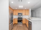 Thumbnail 8 of 49 - A modern kitchen with wooden cabinets and stainless steel appliances.