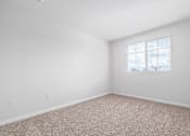 Thumbnail 13 of 49 - A room with a window and carpeted floor.