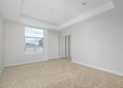 Thumbnail 10 of 49 - A room with a carpeted floor and a window with blinds.