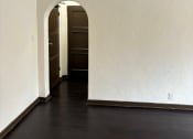 Thumbnail 32 of 35 - an empty room with white walls and a dark wood floor
