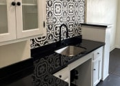 Thumbnail 29 of 35 - a black and white kitchen with a sink and white cabinets