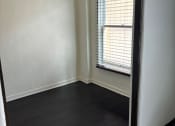 Thumbnail 34 of 35 - an empty room with wood floors and a window