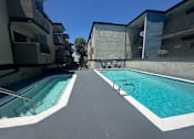 Thumbnail 2 of 19 - a swimming pool is next to an apartment building