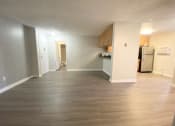Thumbnail 8 of 11 - an empty living room and kitchen with a wood floor