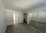 Thumbnail 5 of 19 - an empty living room with a large mirror and wooden floors