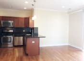 Thumbnail 11 of 23 - a kitchen with wood floors and a black counter top