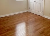 Thumbnail 19 of 23 - a bedroom with hardwood floors and a white door with a window