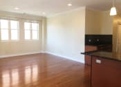 Thumbnail 12 of 23 - an empty living room with a kitchen in the background