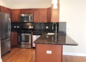 Thumbnail 7 of 23 - a kitchen with black granite countertops and stainless steel appliances