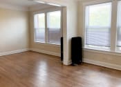 Thumbnail 31 of 38 - an empty room with hardwood floors and three windows