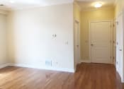 Thumbnail 18 of 23 - a bedroom with white walls and a wooden floor