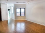 Thumbnail 34 of 48 - a bedroom with hardwood floors and a window