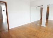 Thumbnail 37 of 48 - a bedroom with white walls and a wooden floor