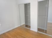 Thumbnail 36 of 48 - a bedroom with a wooden floor and a closet with glass doors